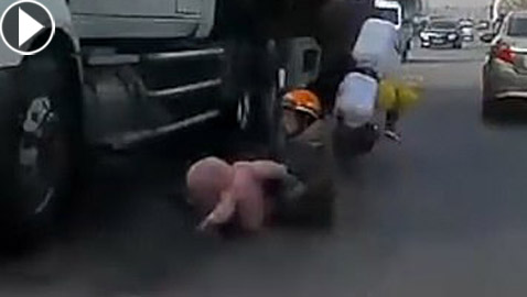 أم شجاعة تنقذ طفلها من الموت المحتم سحقا تحت عجلات شاحنة ضخمة!