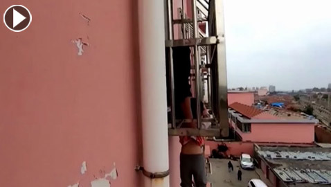 طفل يتدلى من نافذة بمبنى شاهق وصرخاته تلفت انتباه المارة